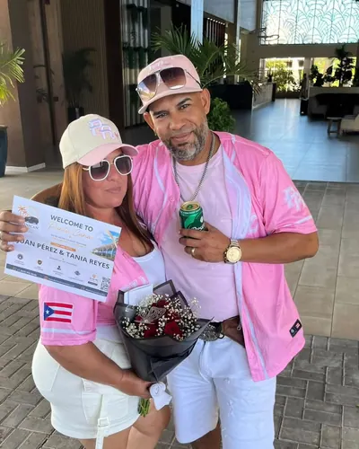 Couple with flowers and their welcome sign at the hotel