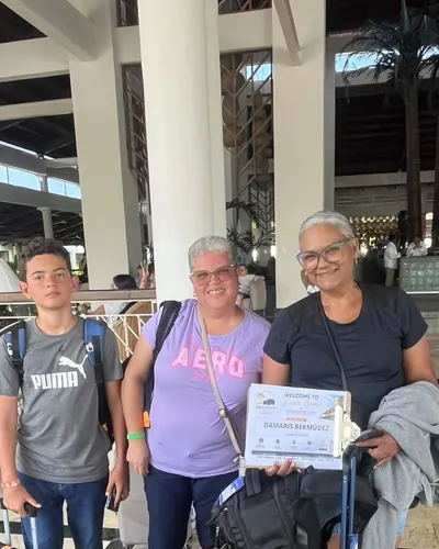 Family with their suitcases and welcome sign