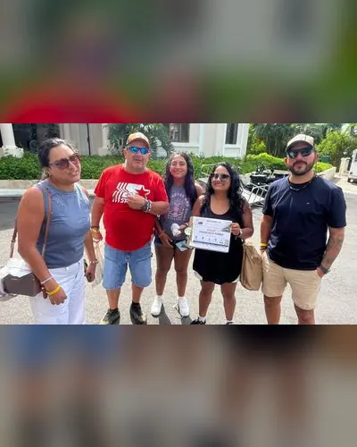 Group of five friends with their welcome sign